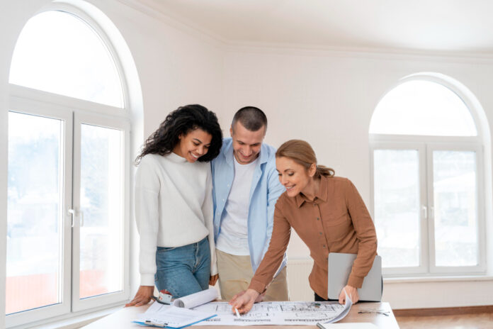 casal com uma corretora vendo o seu financiamento imobiliáiro